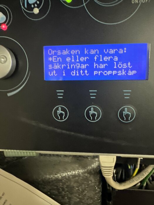 Digital display på maskin med textfelmeddelande på svenska och symboler för handjustering.