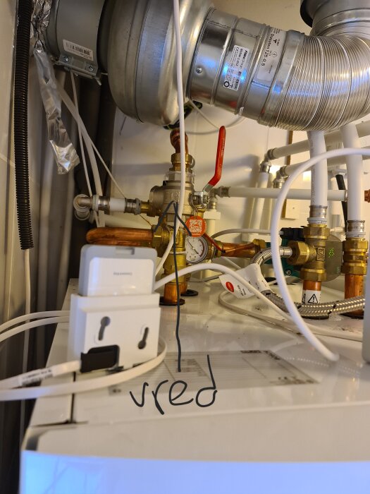 Ventilationssystem, rörledningar, vägguttag och laddare på en virrig och trång plats.
