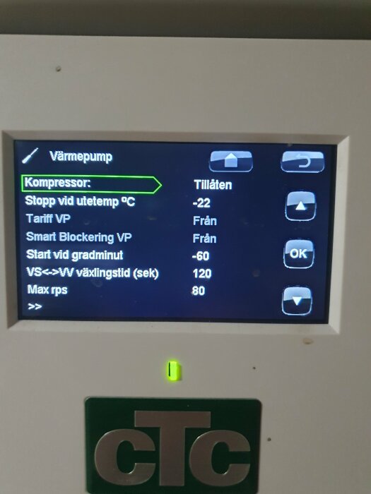 Digital displaypanel för värmepump, visar temperaturinställningar och driftstatus, grön lampa indikerar aktivitet.