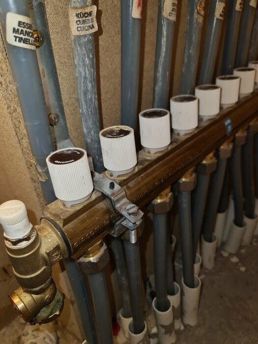 Rörsystem, etiketterade för olika ändamål, med vattenmätare och justervred, installationsmiljö, teknisk infrastruktur.