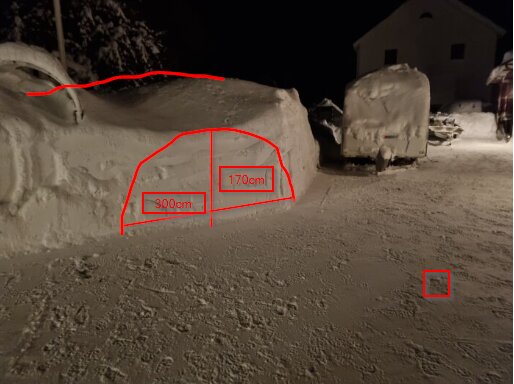 Vinterlandskap nattetid med snöväggar, fordon täckta av snö, röda måttmarkeringar synliga.