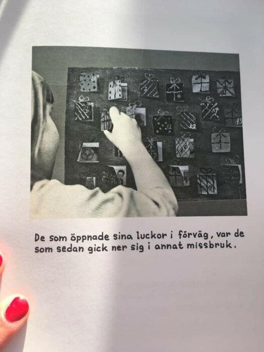 Person bakifrån tittar på en vägg med illustrerat adventskalender, händer pekar, nedre text på svenska.