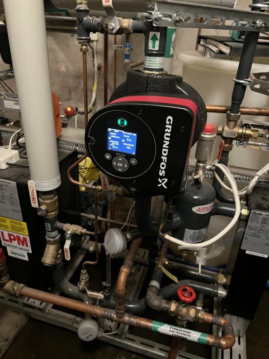 GRUNDFOS cirkulationspump, rör, ventiler, och instrument i ett tekniskt utrymme.