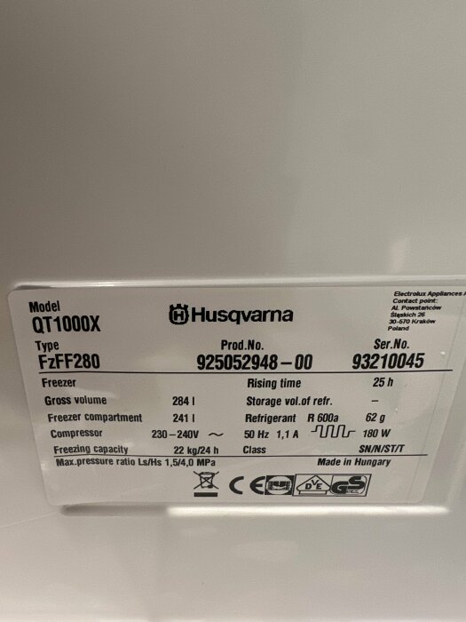 Etikett med tekniska specifikationer för en Husqvarna frysenhet, inkluderar modellnummer, kapacitet och elektriska krav.
