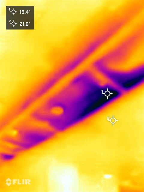 Värmekamera-bild visar temperaturvariationer, kallare områden i lila, varmare i gult. Två mätvärden angivna.