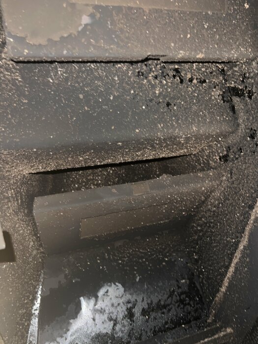 Närbild av smutsig bil i svartton med tydliga saltfläckar och smuts.