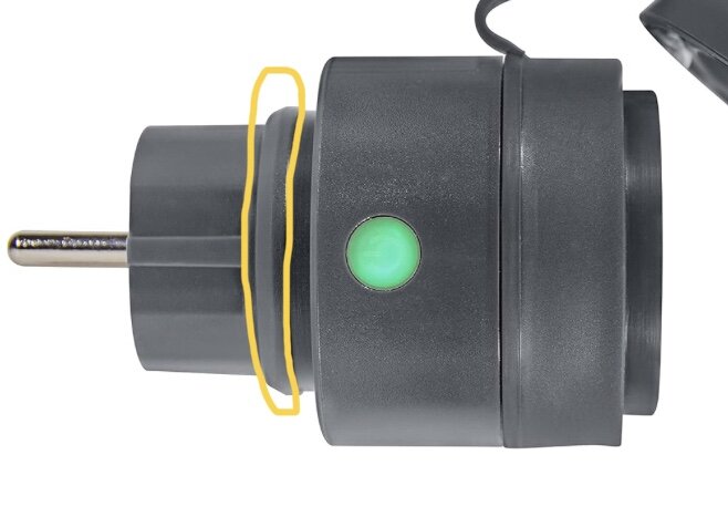 Strömadapter med grön indikatorlampa, gul ring, svart hölje, mot vit bakgrund.