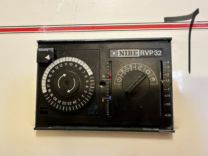 NIBE RVP32; termostat för värmestyrning med klocka, temperaturjustering och energisparlägen symboliserade av sol och måne.