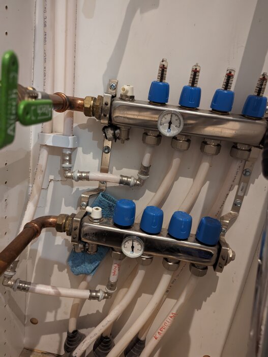 Inomhus VVS-installation med rör, mätare och ventiler för vattenfördelning.