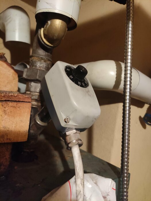 Termostatventil på vattenrör, rost, skala, ovanför hink, under diskho, installation för temperaturreglering, hemmamiljö, kalkavlagringar.