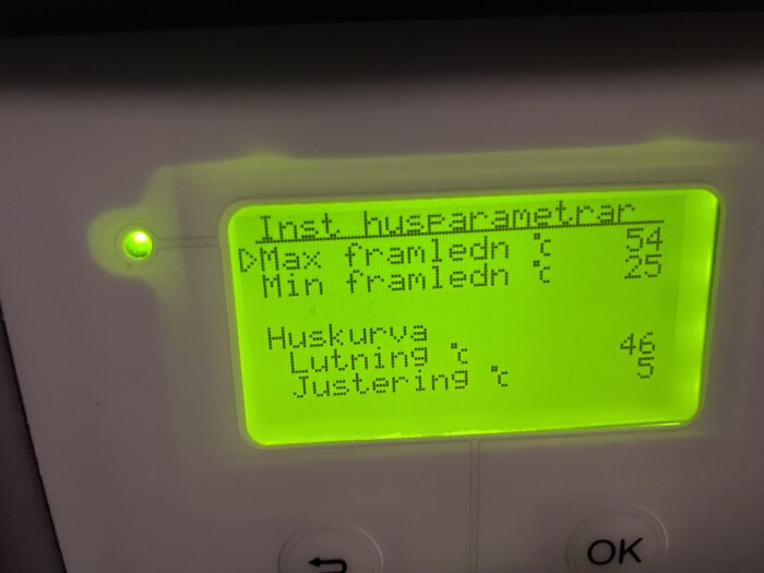 Digital display visar innetemperatur, max/min framledningstemperatur och justeringar för husvärme — Grön bakgrundsbelysning, knappar nedanför.