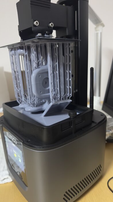 3D-skrivare under utskriftsprocess med synlig resin och UV-härdat objekt inuti, varumärket ELEGOO synligt.