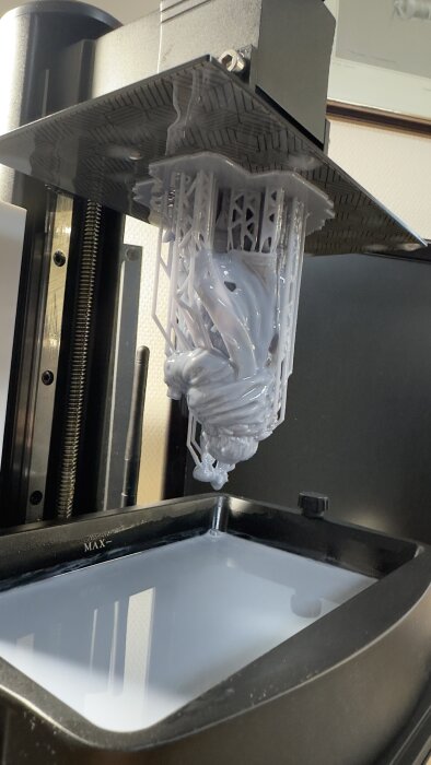 3D-skrivare som skapar ett objekt med stereolitografiteknik, resinbassäng synlig nedanför.