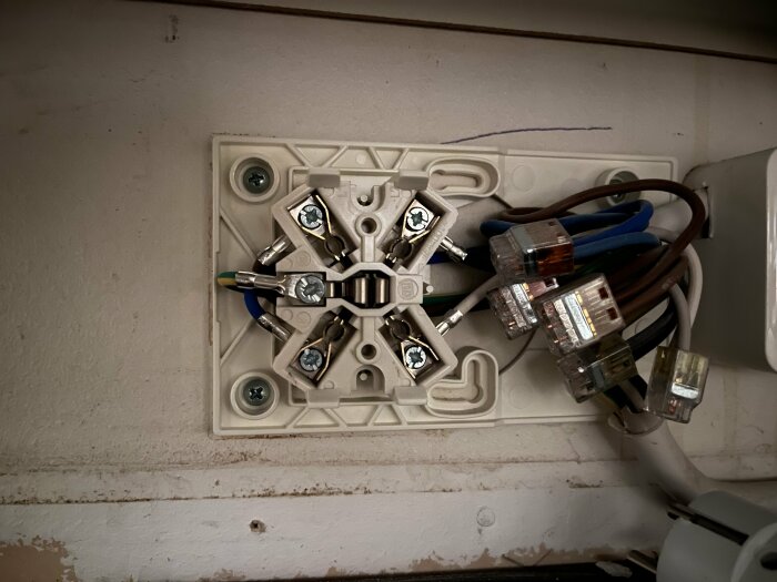 Elektrisk kopplingsdosa, kablar, WAGO klemmor, installationsarbete, kabelkanal, vägg, ej fullständigt monterat.