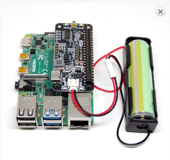 Enkortsdator ansluten till batterimodul via kabel, som har USB-portar, HDMI och GPIO-stift.