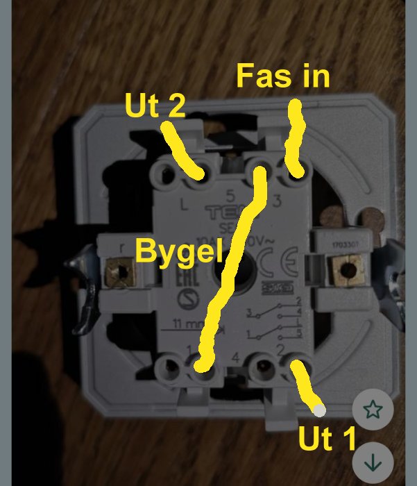 Eluttag med gul markering för elinstallation: "Fas in", "Ut 1", "Ut 2", "Bygel".