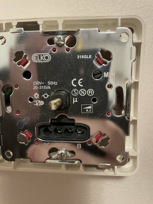 Elektrisk vägguttagsinstallation utan frontplatta, märkt med "ELKO", kablar ej anslutna, monteringsdetaljer synliga.
