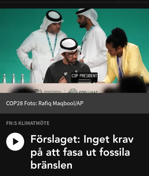 Människor i diskussion, konferensmiljö, COP-president, text om fossila bränslen, United Nations logotyp.