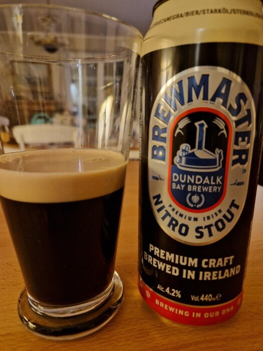 Ett glas mörkt öl bredvid en ölburk med texten "Brewmaster Nitro Stout, Premium Craft Brewed in Ireland".