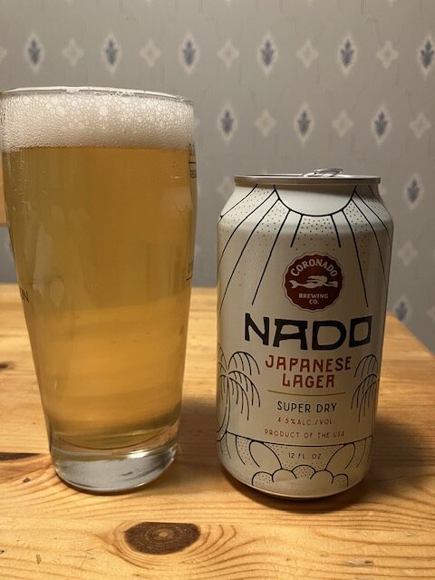 En burk japansk lageröl från Coronado Brewing med ett glas fylld med öl, på ett träbord.