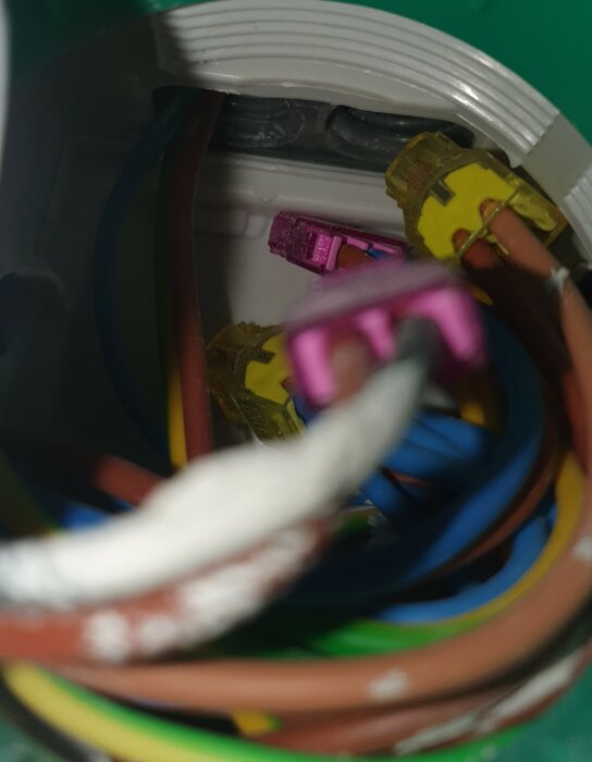 Elkoppling inuti dosa: kablar, isolering, färgade höljen, elektriskt arbete, säkringskomponenter.