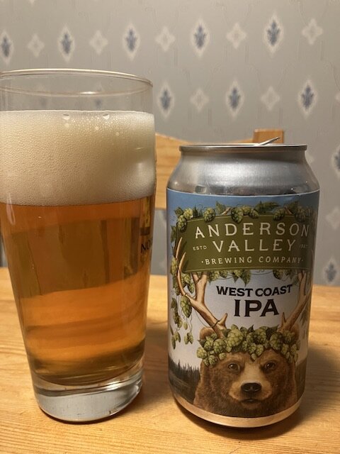 Ett glas med öl vid sidan av en IPA-ölburk från Anderson Valley Brewing Company.