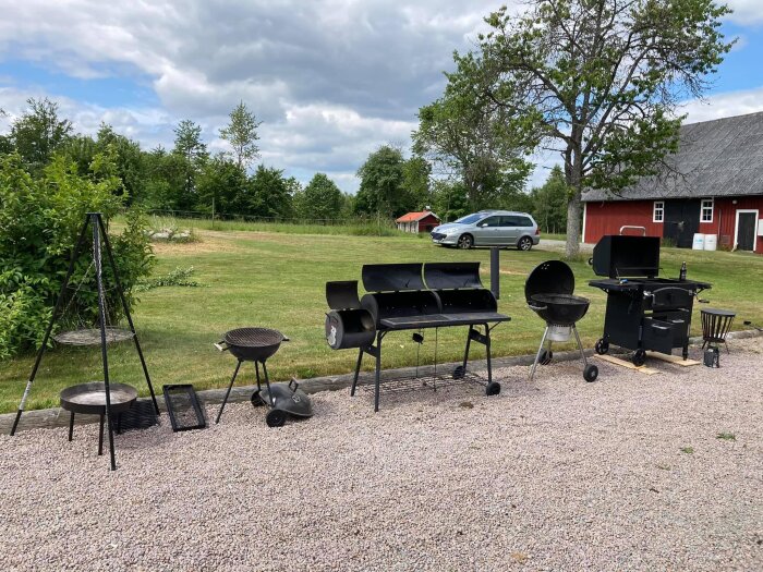 Grillar och rökare på grus, landskap med träd, röd lada, delvis molnig himmel.