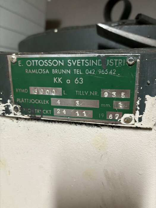 Grönt metallskylt på apparat, text, siffror, telefonnummer, slitage, svetsindustri, Ramlösa Brunn, 1967.