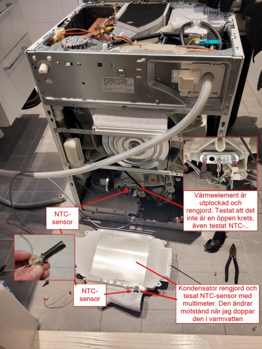 Öppen diskmaskin, demonterad med framhävda komponenter: värmeelement, NTC-sensorer och kondensator. Reparation eller felsökning pågår.
