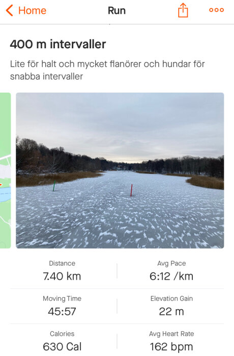 Skärmupptagning av löpapp, snötäckt bana, löpardata, 7.40 km, hal väderlek, staketstolpar.