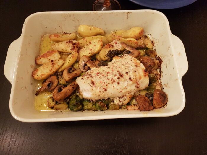 Ugnsbakad måltid med kycklingbröst, potatisar, champinjoner och brysselkål i en ugnsform.