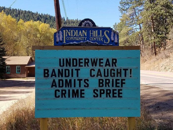 Skylt med vits: "UNDERWEAR BANDIT CAUGHT! ADMITS BRIEF CRIME SPREE" utanför Indian Hills Community Center.