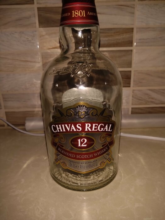 Tom Chivas Regal-flaska, 12 år, blended scotch whisky, köksbänk, kakelvägg i bakgrunden.