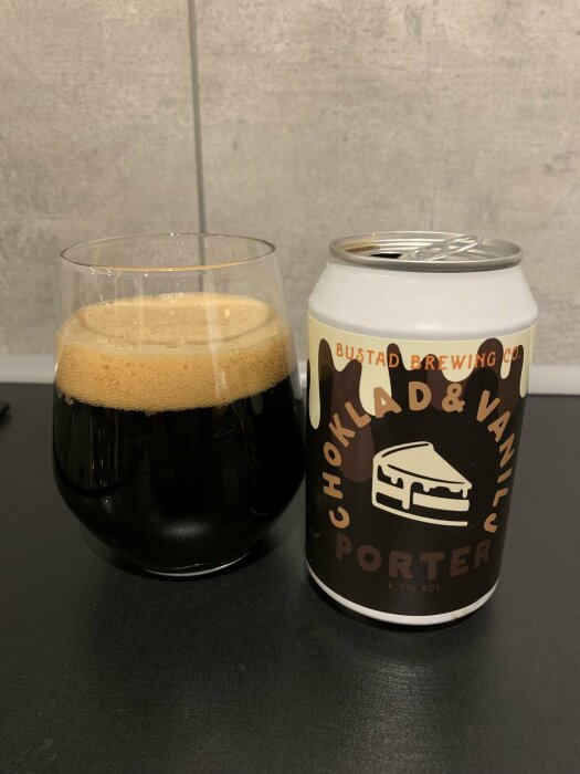 Ett glas mörkt öl och en ölburk med texten "Choklad & Vanilj Porter".