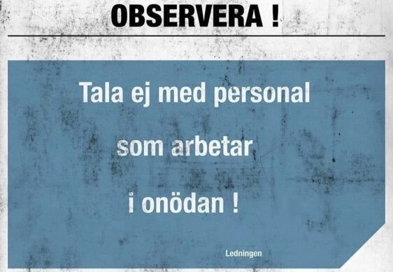 Skylt med text: "OBSERVERA! Tala ej med personal som arbetar i onödan!" - från ledningen. Nedsliten bakgrund.