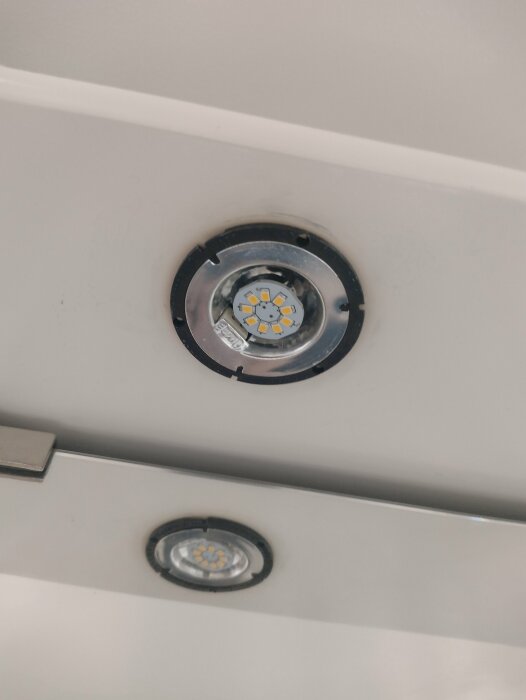 Två inbyggda LED-spotlights i tak, en tänd och en släckt.