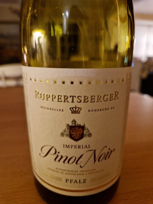 Vinflaska med etikett "Ruppertsberger Imperial Pinot Noir, Pfalz" i förgrunden, oskarp bakgrund.