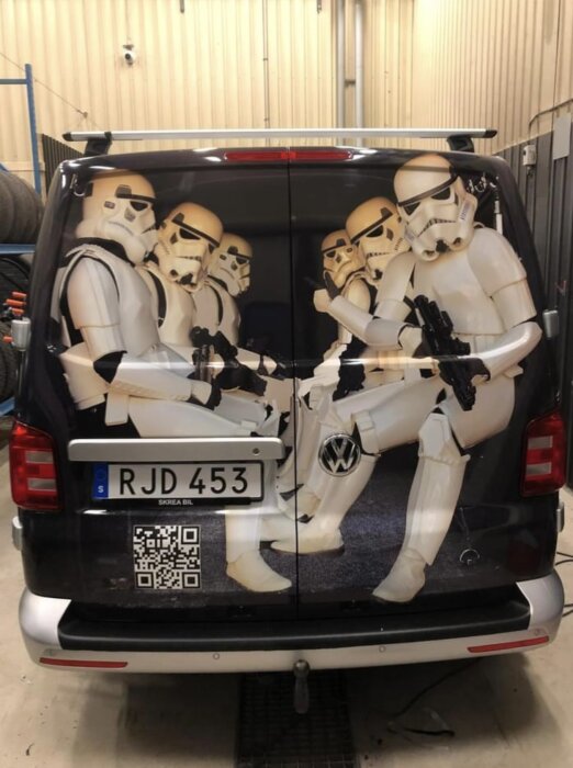 Minibuss bakdel med Stormtrooper-dekor, illusion av sittande Star Wars-figurer. Registreringsskylt och QR-kod synliga.