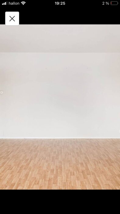 Tomt rum, vita väggar, trägolv, en elektrisk uttag, minimalistisk, ingen möblering, inomhus, ljust.