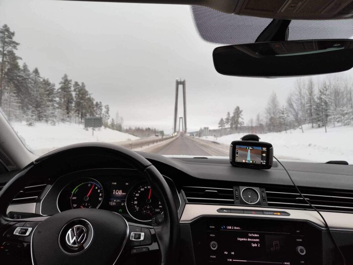 Förarvy i bil, vinterlandskap, snö, GPS, hastighet 108 km/h, bro i bakgrunden.