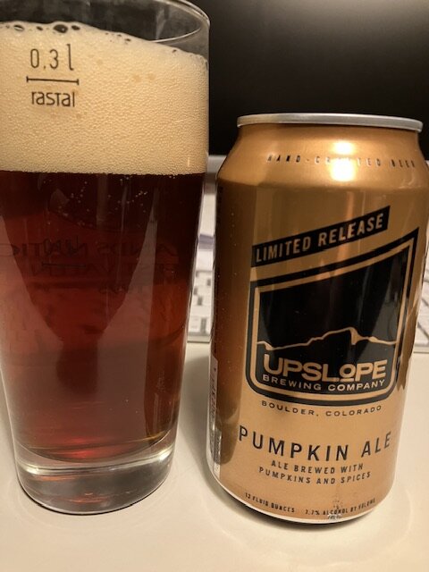 Ett glas öl märkt "rastal" och en burk Upslope Pumpkin Ale. Limited release.