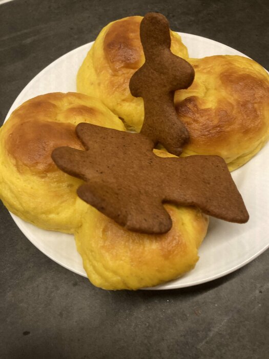 Lussekatter och pepparkaksfigurer på tallrik, traditionellt svenskt julbak.