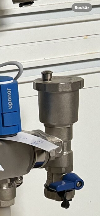 Metallfilter med blå Öppna/Stänga-ventiler, troligtvis del av VVS-system, märkt "Uponor".