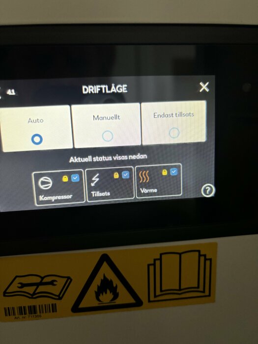 Digital kontrollpanel för värme eller kylsystem, med ikoner och text på svenska, varningsetiketter synliga nedtill.