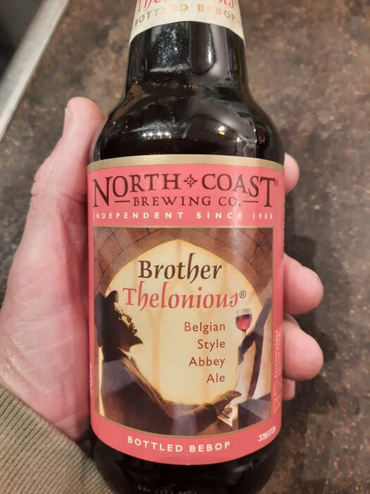 Hand håller North Coast Brewing ölflaska, Brother Thelonious, belgisk stil Abbey Ale.