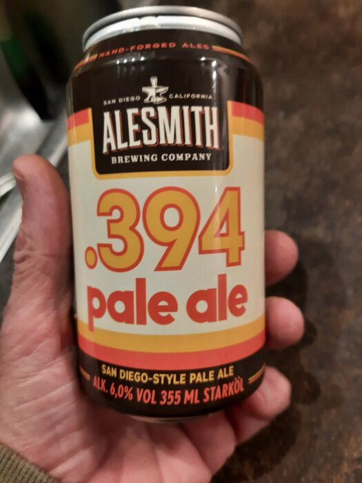 En hand håller en ölburk märkt "Alesmith .394 pale ale" med texten "San Diego-style pale ale."