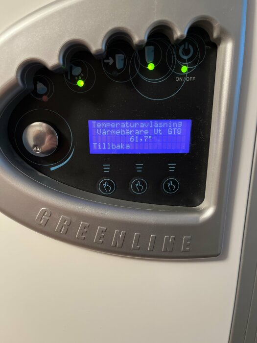 Digital display på en värmepanna med temperaturinställningar, knappar och logotyp "GREENLINE".