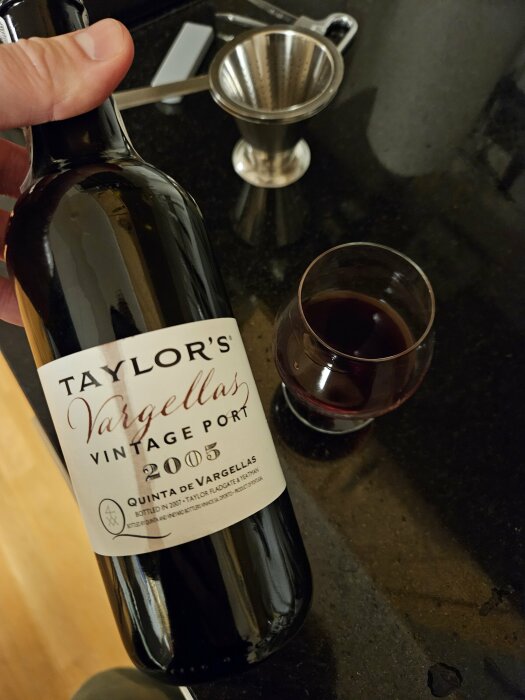 Portvin, glas, flaska, sil, mot svart marmorbänkskiva. Taylors Vargellas Vintage Port 2005.