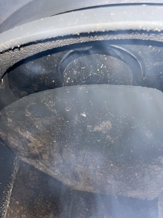 Närbild på däck och skärmkant på ett fordon, smuts och grus synlig, indikerar nyligen användning.