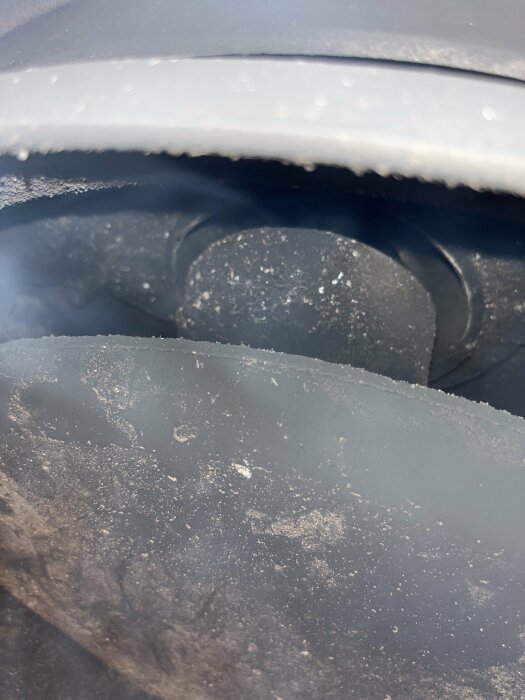 Närbild av ett fordon med is och snöpartiklar, fokus på textur och belysning, kallt motiv.